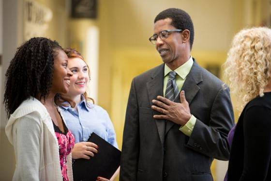 Photo of a Chatham University professor speaking with students at an event